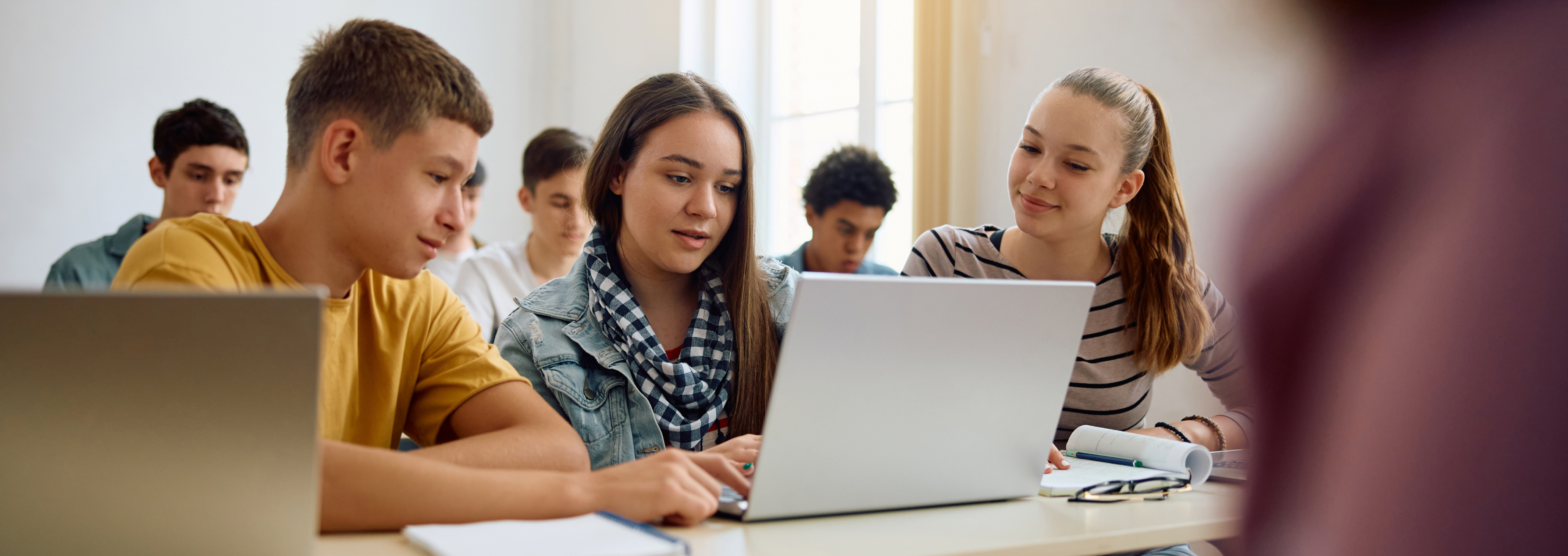 Students watching content on laptop in classroom